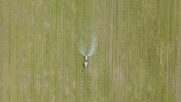 Aerial View of a Tractor Which Spraying Chemical Insecticide or Fertilizers to Orchard Trees