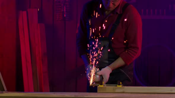 Worker Cuts Metal with Angle Grinder. Sparks and Smoke Fly in Slow Motion