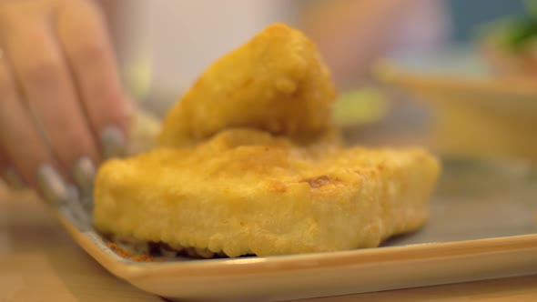 Pouring fried cheese with lemon juice