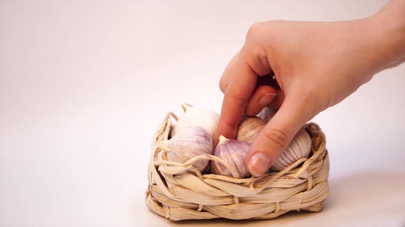 Garlic in a Wicker Basket, on a White Background. Dried French Garlic. Red Garlic.