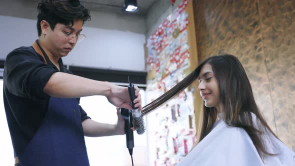 Hairdresser Using Hairdryer on Customer