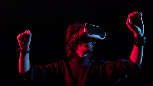 Man with VR Helmet on His Head Playing in Redblue Lights Online Game