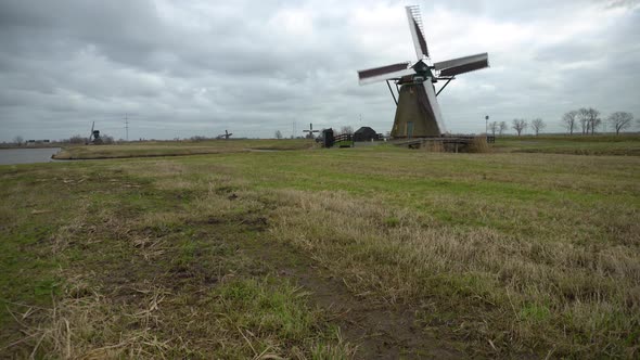 Dutch windmill turning fast in strong winds, camera tilt up reveal