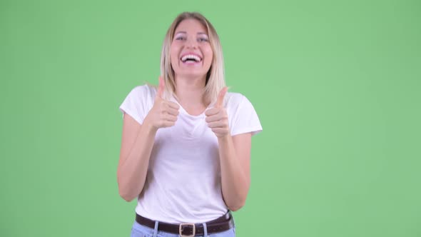 Happy Young Beautiful Blonde Woman Giving Thumbs Up and Looking Excited