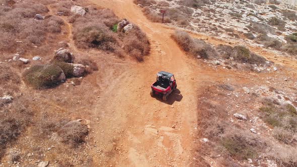 A dune buggy comes to a fork in the road on a dirt path and has to choose a direction