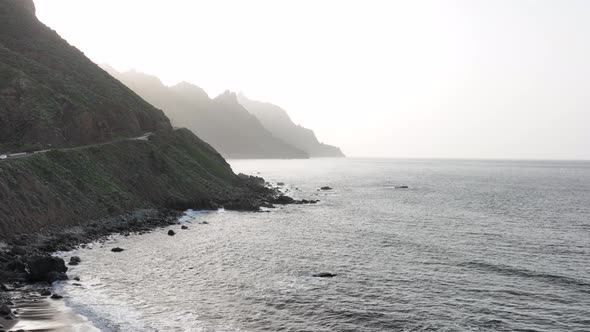 Rocky Volcanic Beach Surrounded By High Mountains and Cliffs Aerial Drone View