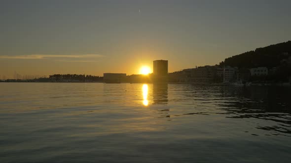 Timelapse of the sea and the coastal city at sunset