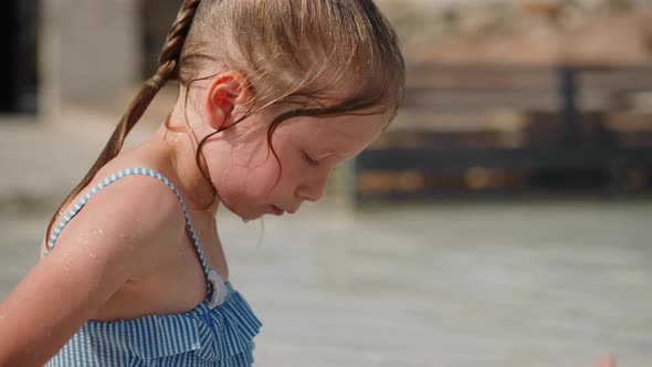 Thoughtful Little Girl in Swimsuit Rests at Exotic Resort