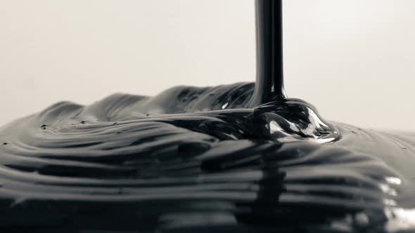 Thick Black Paint Pours On White Surface