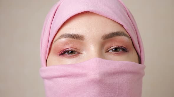 Muslim Woman in a Pink Headscarf Completely Covering Face