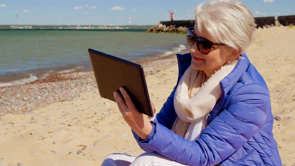 Senior Woman with Tablet Computer on Beach