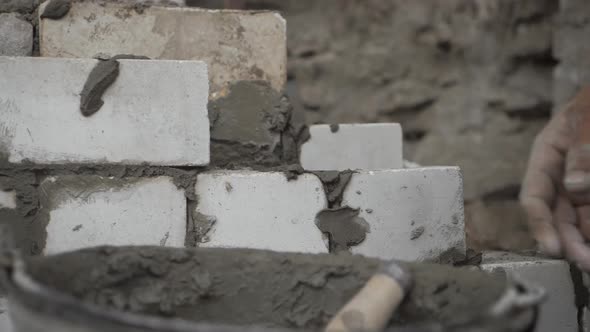 Construction Worker or Mason Laying Bricks and Creating Walls. Bricklayer Laying Bricks To Make a