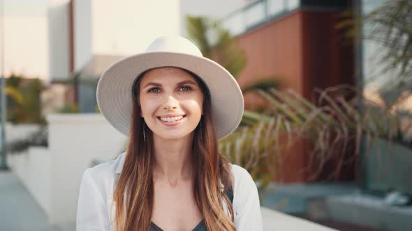 Female Tourist in Summer Hat Posing on City Street