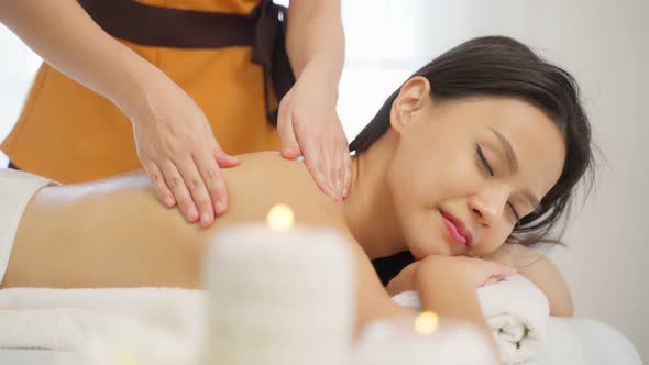 Asian young woman feeling happy and relax during back massage with oil.
