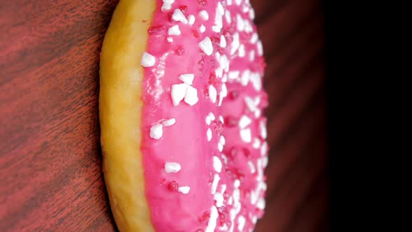 Tasty Doughnut with Coloured Cream on Brown Wooden Table