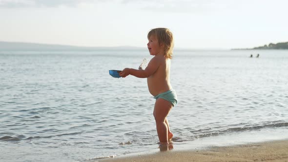 European Little Girl is Playing on the Beach Near the Sea