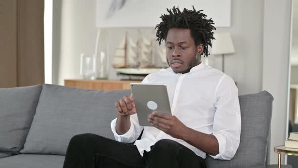 Failure, African Man with Loss on Tablet in Home 