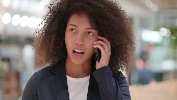Angry Young African Businesswoman Talking on Smartphone