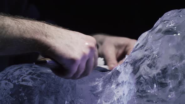 Carving an Ice Sculpture a Man is Using a Knife to Create an Ice Sculpture