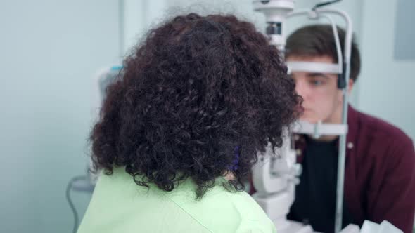 Back View Professional Doctor Checking Pupil on Retina Camera Turning Looking at Camera Smiling