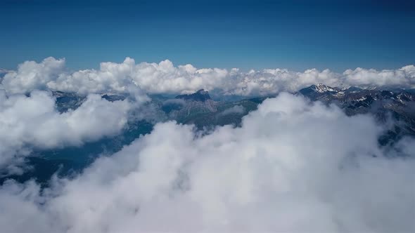 Aerial Flight Through Clouds Over Mountain Landscape