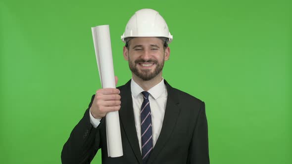 Cheerful Engineer Showing Construction Blueprint Against Chroma Key