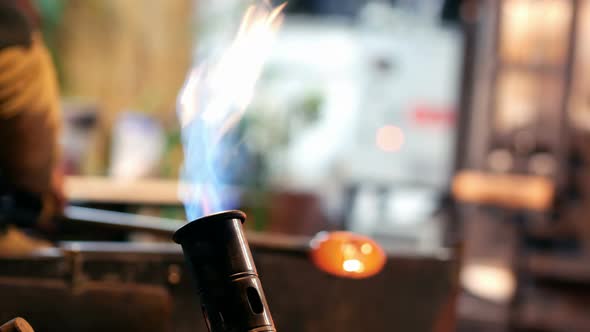 Glassblower shaping a molten glass