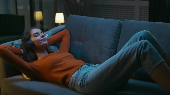 Young Woman is Lying at Home on the Couch with her Eyes Closed