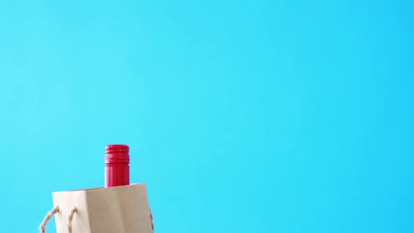 Bottle in shopping bag on blue background