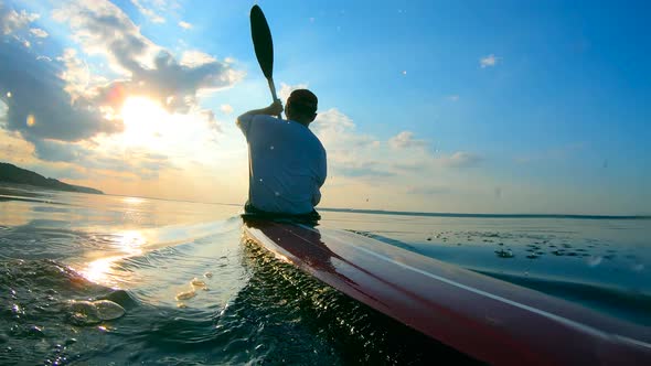 Backside View of a Male Boater Navigating a Canoe