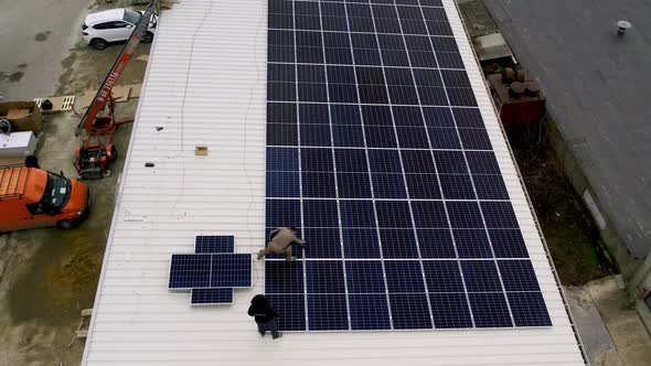 Solar Technician Installing Solar Panels on House Roof