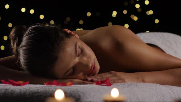 Girl Sleeps After Spa Treatments on Rose Petals, Burning Candles