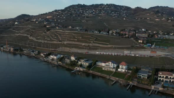 Aerial of train driving through beautiful Swiss landscape. Filmed in Cully, Switzerland