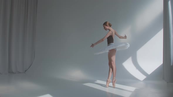 Female Dancer Does Ballet Exercises in Stage Dress with Open Back. Rehearses Dance Moves in the