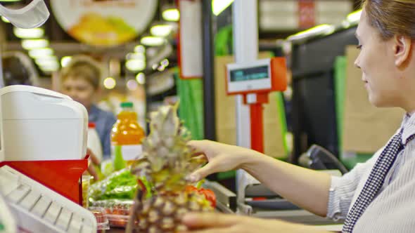 Cashier Working at Register in Supermarket