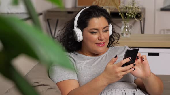 Woman in Headphones Listens To Music on Smartphone