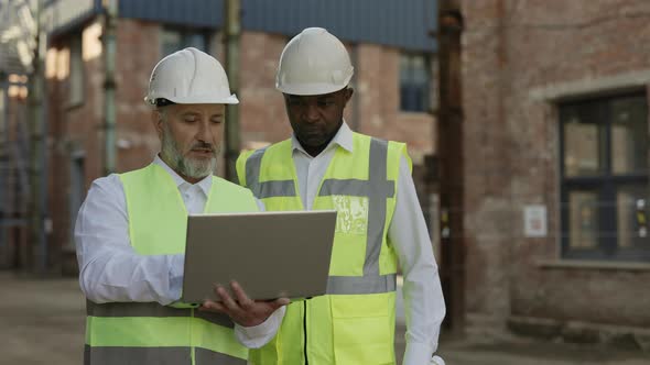 Team of Engineers Working on Laptop at Building Site