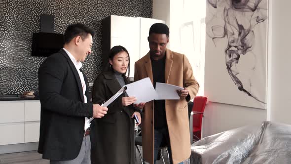 Realtor Explaining Agreement To Couple In New Apartment