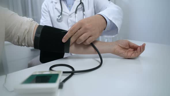 Doctor Measuring Pressure to Patient With Complains, Healthcare and Diagnostics