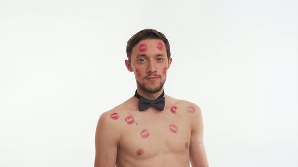 Blow kiss. Close up man portrait with beard, stained red lipstick marks on body on white background