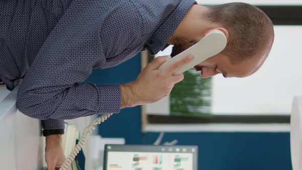 Vertical Video Company Secretary Talking on Landline Phone Call at Desk