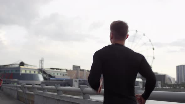 Strong Male Athlete Running in City in Early Morning