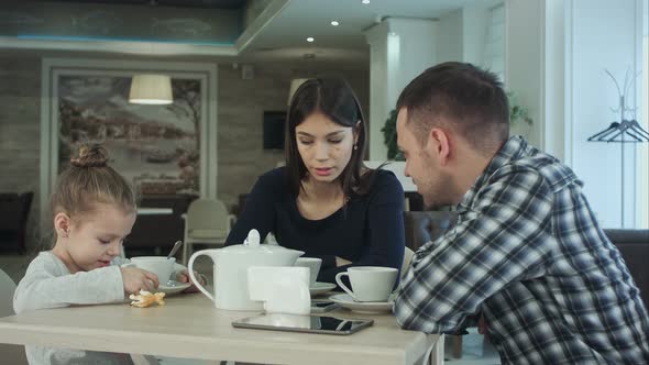 Family Enjoying Tea In Cafe Together