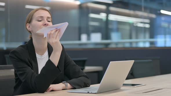 Businesswoman with Laptop Flying Paper Plane