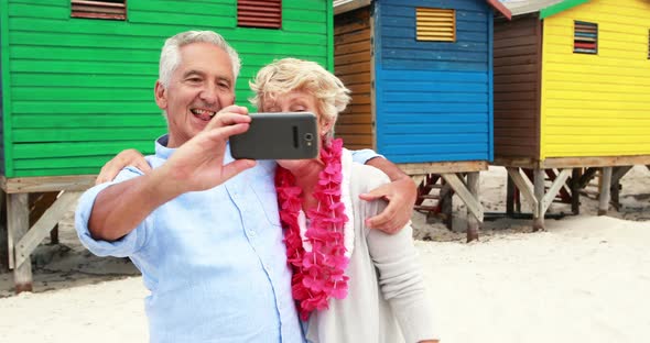 Senior couple taking a selfie on the beach