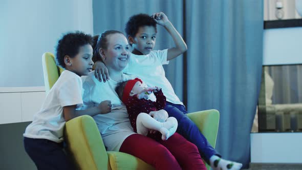 Mother Sitting in a Rocking Chair with Her Children