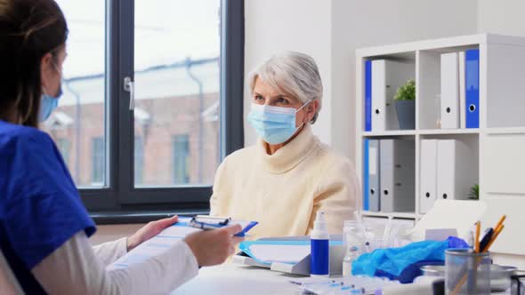 Doctor with Clipboard and Senior Woman at Hospital