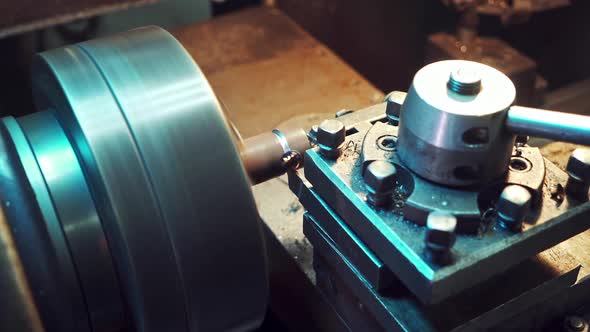 A detail is cutting with using a rotating lathe producing remnants of metal shavings