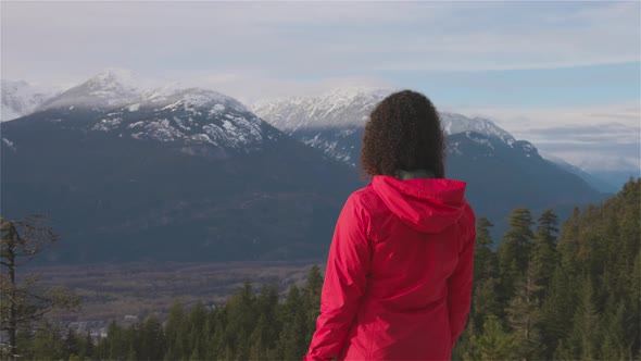 Adventurous Girl Hiking in the Mountains During a Sunny Winter Sunset