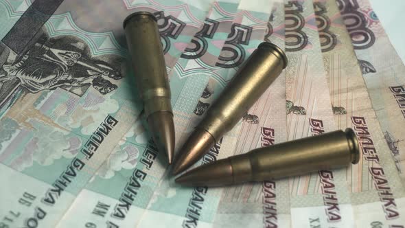 War Economy Concept Machine Gun Bullets on Russian Ruble Banknotes Close Up